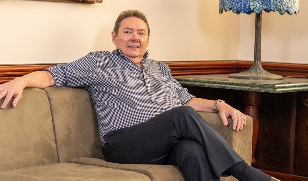 Ivens posa para a foto sentado em um sofá